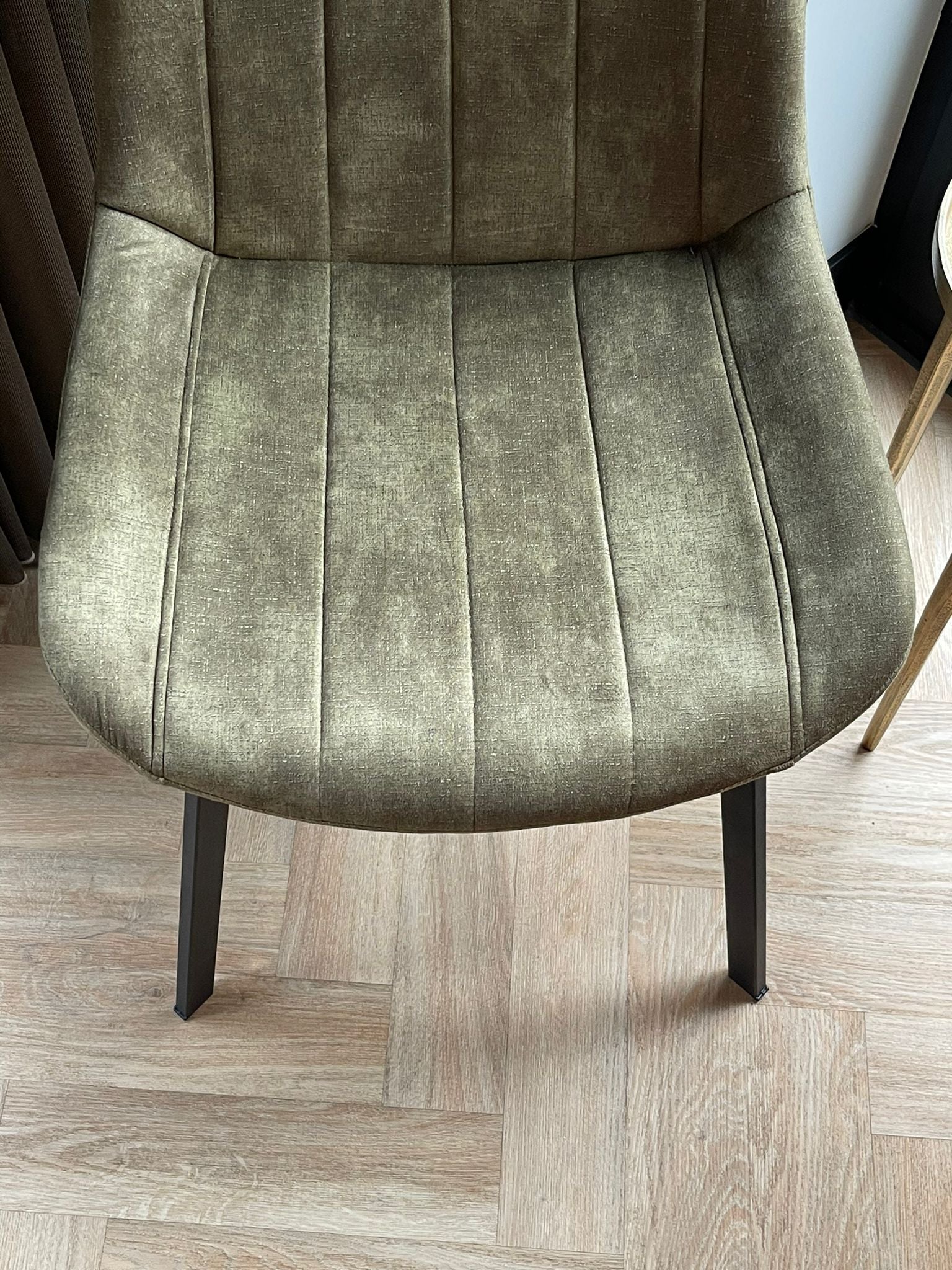 Eetkamerstoel Marilene velvet in groen, detail van zitting en metalen poten, modern design uit 2025 voor stijlvolle interieurs